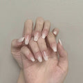 Close-up of a hand with neatly manicured nails against a neutral background