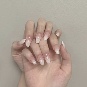 Close-up of a hand with neatly manicured nails against a neutral background