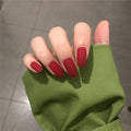 Hand with red nail polish on a neutral background
