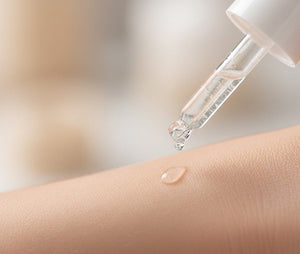 Dropper with clear liquid being applied to skin