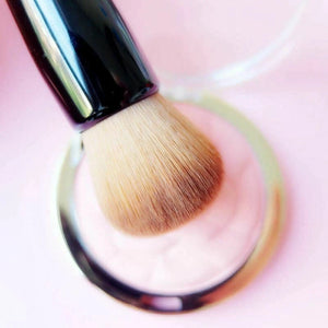 Makeup brush with a pink gradient background