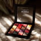 Makeup palette with colorful swatches on a textured surface