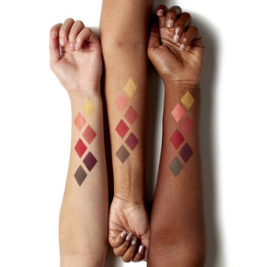 Three arms with swatches of makeup colors on their wrists against a white background