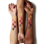 Three arms with swatches of makeup colors on their wrists against a white background