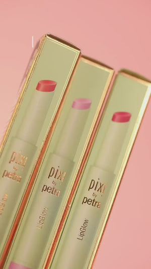Three PIXI by Petra lip glosses in their packaging on a pink background