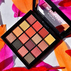Makeup palette with colorful eyeshadows on a vibrant background