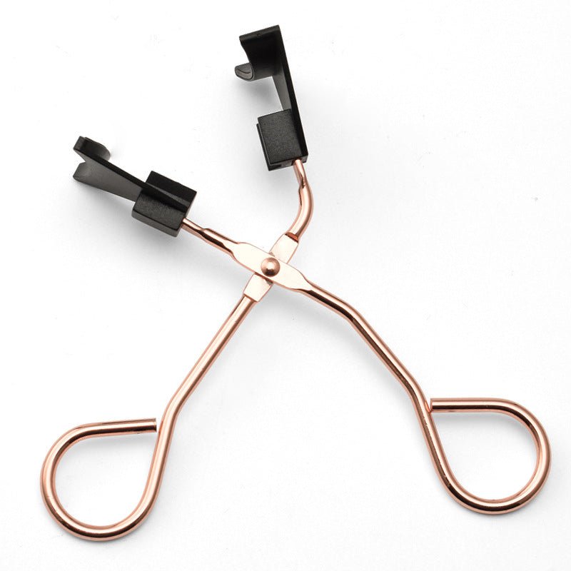 Rose gold eyelash curler on a white background
