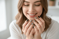 Woman with stylish nail art smiling and showing off her hands.