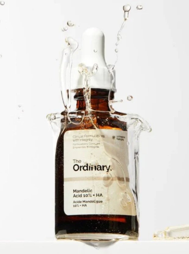 Bottle of The Ordinary Mandelic Acid 10% + HA serum with droplets on a white background