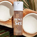 Anastasia Beverly Hills Dewy Set setting spray bottle with coconuts in the background