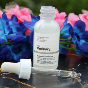 Skincare serum bottle with dropper against a floral background