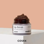 Cosrx lip scrub jar with brown scrub on a beige background