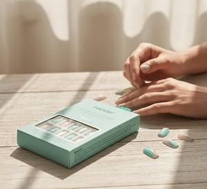 Nail polish set with a matching box on a wooden surface, with hands interacting.