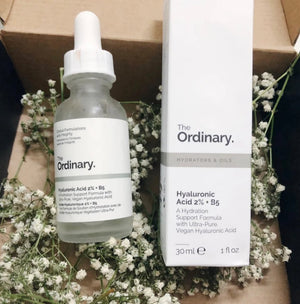 The Ordinary skincare product with dropper bottle and packaging on a floral background