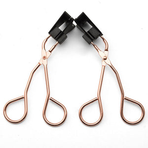 Two rose gold hair clips with black clips on a white background