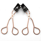 Two rose gold hair clips with black clips on a white background