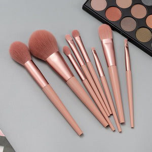 Set of makeup brushes with a makeup palette on a gray background