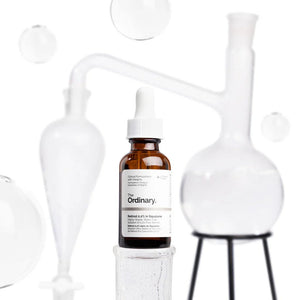 The Ordinary skincare serum bottle on a white background with abstract shapes