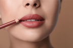 Close-up of a person applying lipstick with a brush