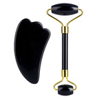 Black facial roller and gua sha tool on a white background