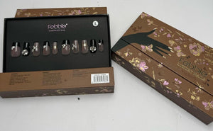 Set of nail polish with a branded box on a white surface
