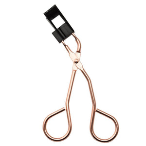 Rose gold eyelash curler on a white background