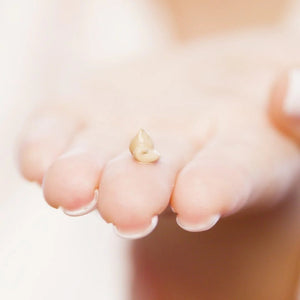 Gold butterfly earring on a person's ear with a soft focus background
