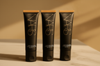 Three black tubes of cream on a beige background