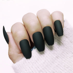 Hand with black matte nail polish on a textured surface